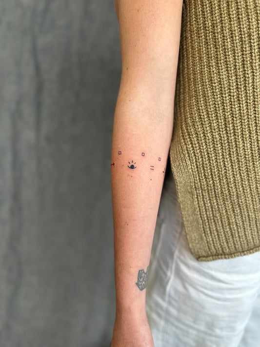 Inner Forearm view of wrap around symbols abstract cave painting paleolithic tattoo design by Eli inking in Bristol