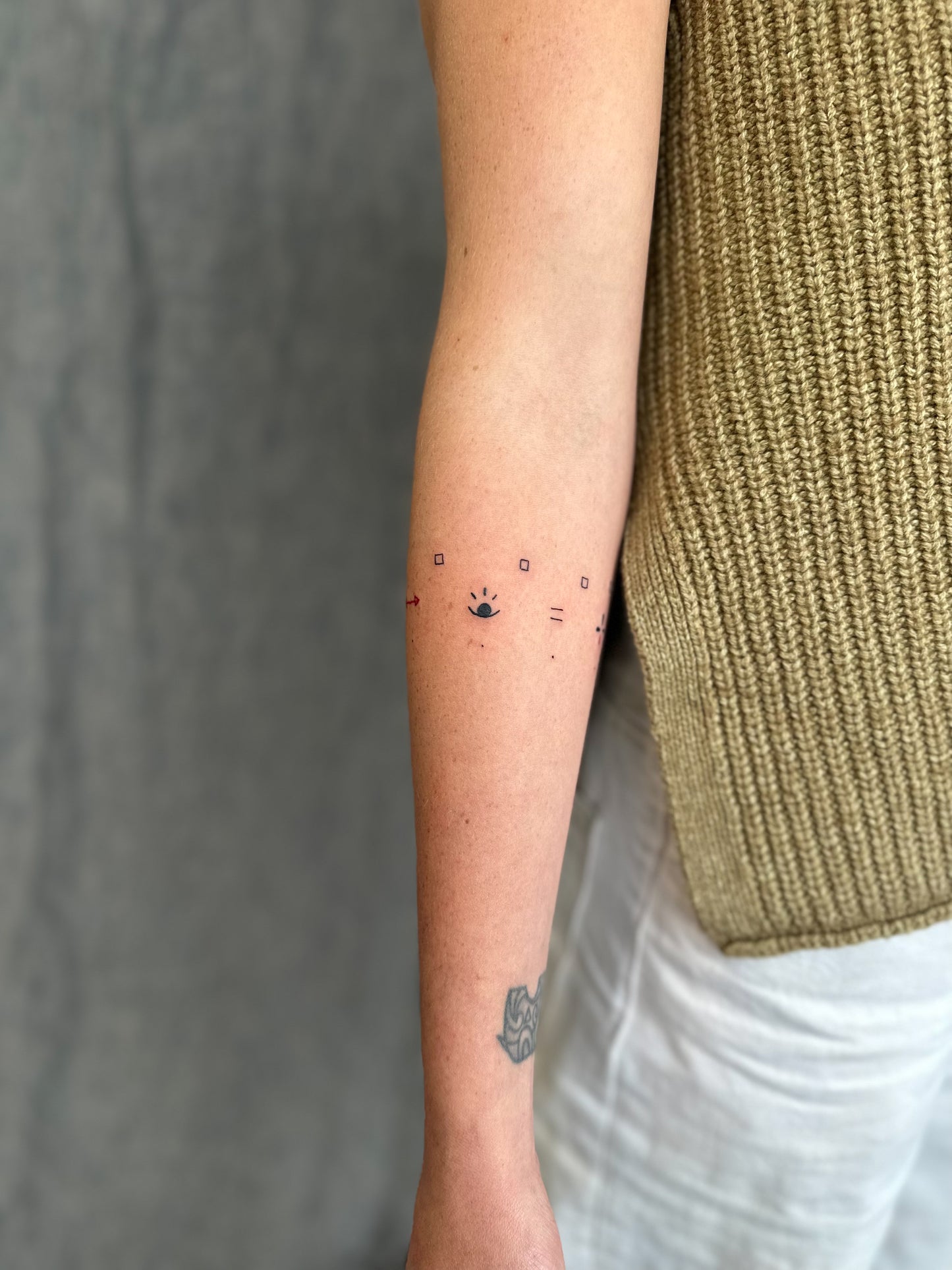 Inner Forearm view of wrap around symbols abstract cave painting paleolithic tattoo design by Eli inking in Bristol 