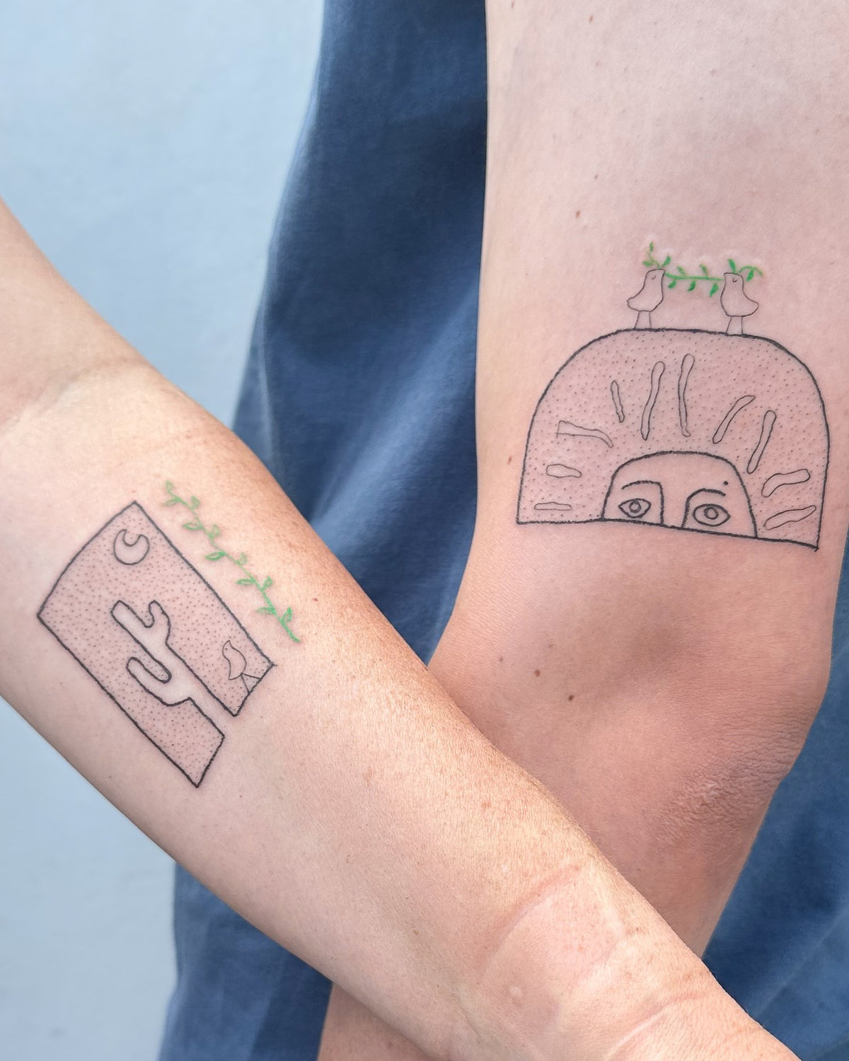 Two tattoos made as a pair, a cactus tile and a peeking sun arch, both with green sprigs, by Eli Inking in Bristol