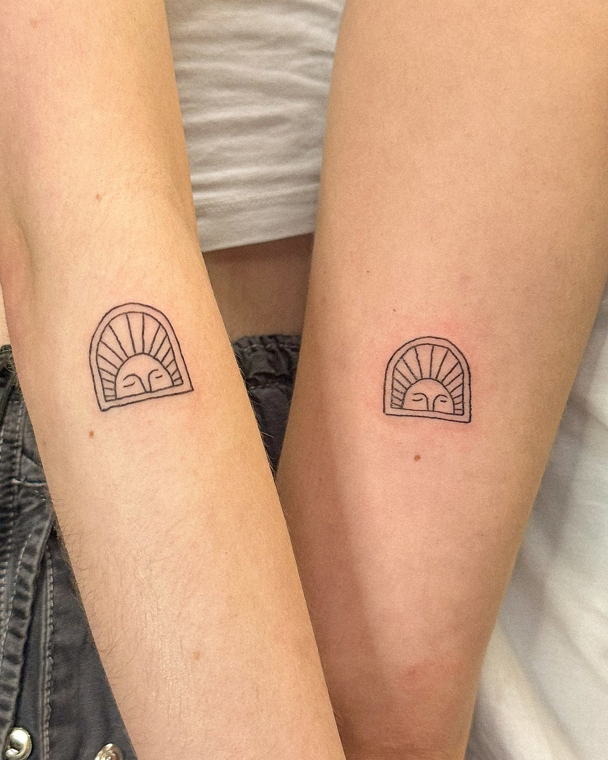 Matching sun arch tile tattoos on two people's forearms, by Eli Inking in Bristol